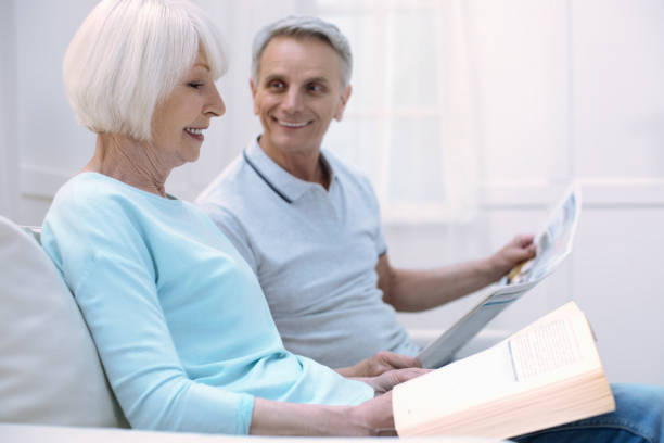 istock Friendly elderly couple sharing news and smiling 875555186