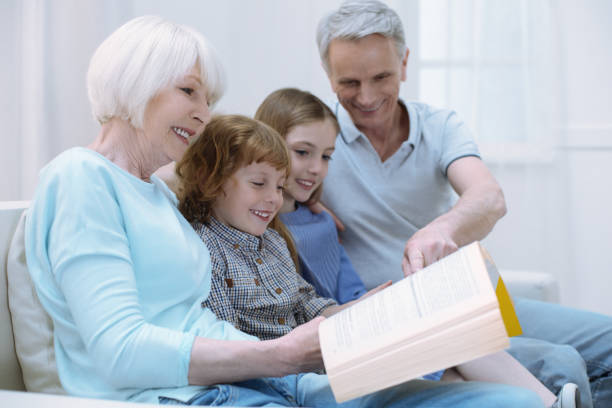 istock Four close relatives sitting together and reading 875557320