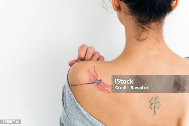 A Woman Is Showing Her Tattoo On Her Back Stock Photo - Download Image Now - Tattoo, One Woman Only, Shoulder