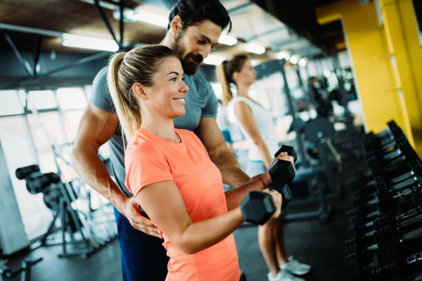 istock Young beautiful woman doing exercises with personal trainer 875564150