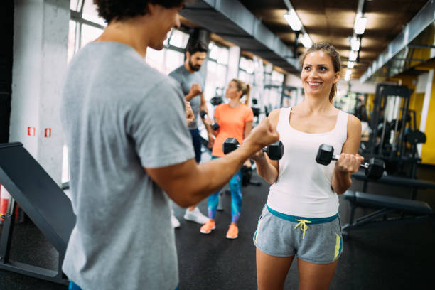 istock Young beautiful woman doing exercises with personal trainer 875564294