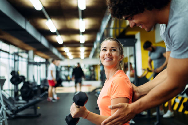 istock Young beautiful woman doing exercises with personal trainer 875564700