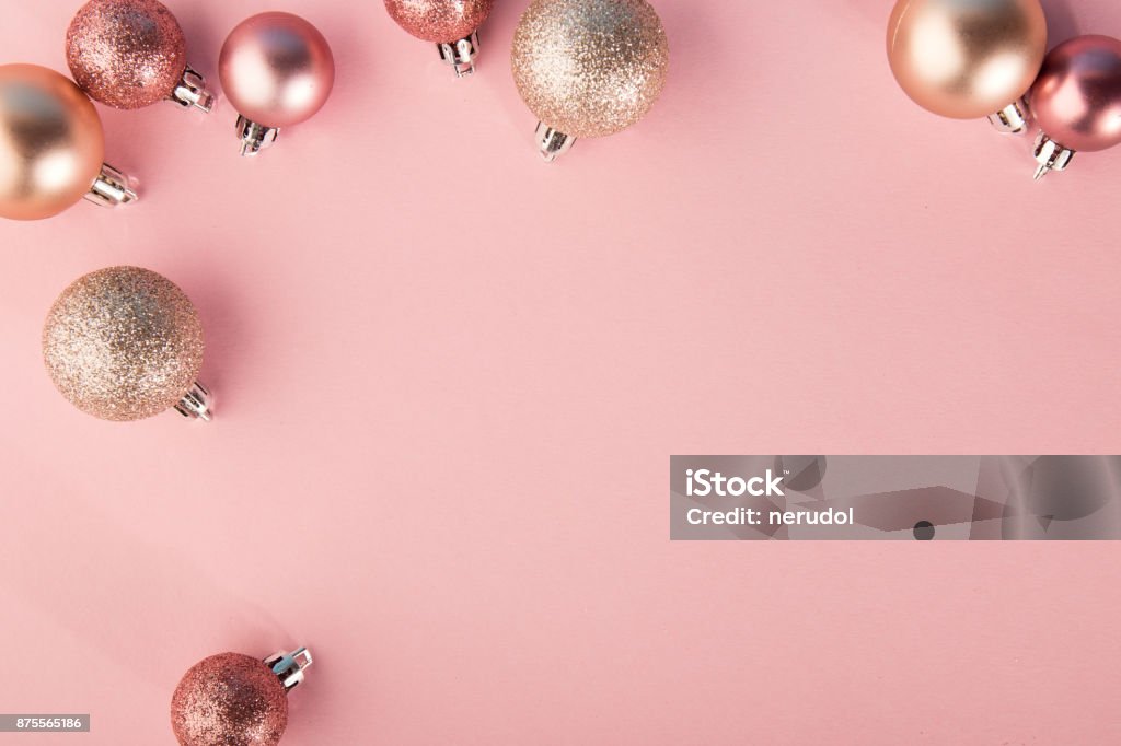 From above shot of bright glittering baubles composed in row on pink background. Pink Color Stock Photo