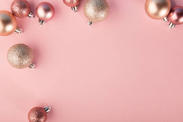From above shot of bright glittering baubles composed in row on pink background. stock photo
