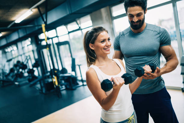 istock Young beautiful woman doing exercises with personal trainer 875568100
