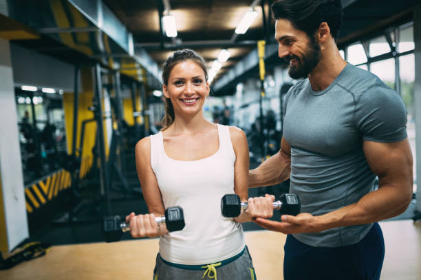 istock Young beautiful woman doing exercises with personal trainer 875568160