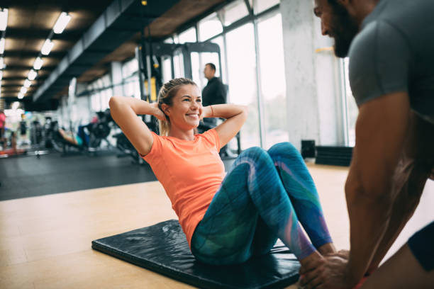 istock Young beautiful woman doing exercises with personal trainer 875568186