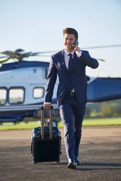 istock Businessman Walking Away From Helicopter Whilst Talking On Mobile Phone 875569574