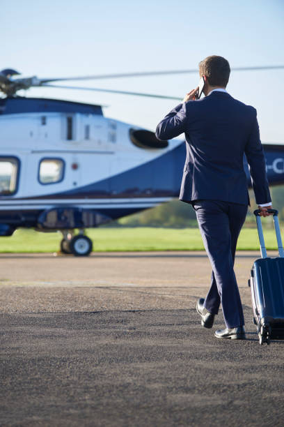 istock Businessman Walking Towards Helicopter Whilst Talking On Mobile Phone 875569674