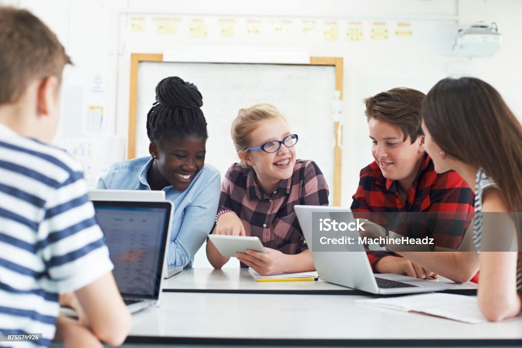 Gruppo di studenti adolescenti che collaborano al progetto in classe IT - Foto stock royalty-free di Aula