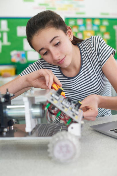istock Female Pupil In Science Lesson Studying Robotics 875575452