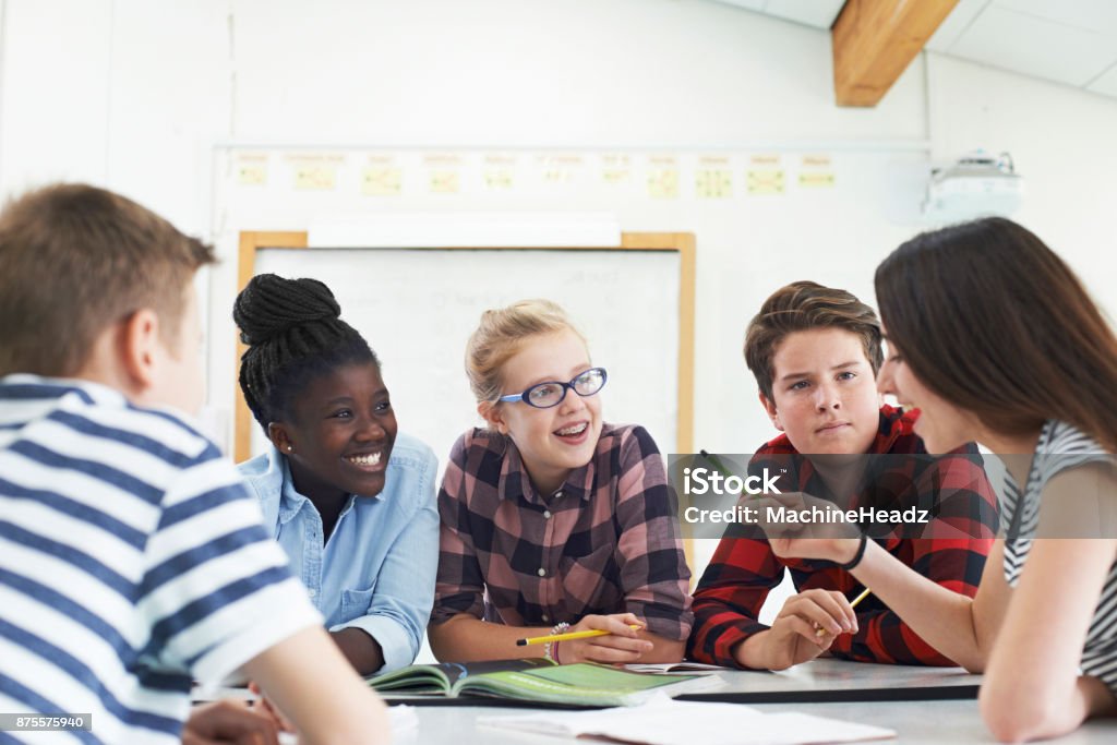 Gruppo di studenti adolescenti che collaborano al progetto in classe - Foto stock royalty-free di Aula