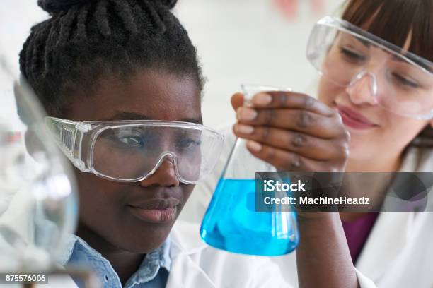 Female Pupil And Teacher Conducting Chemistry Experiment Stock Photo - Download Image Now