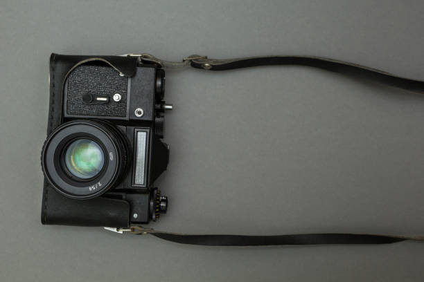 istock Black retro film camera with neck strap. 875579000