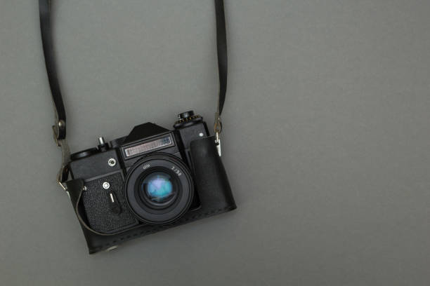 istock Black retro film camera with neck strap. 875579002