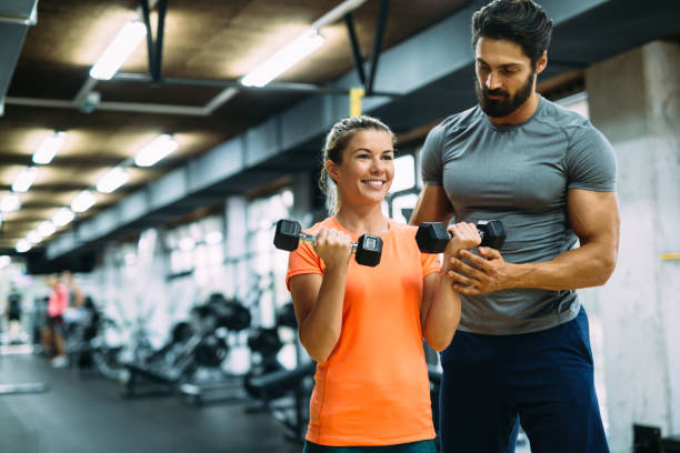 istock Young beautiful woman doing exercises with personal trainer 875579704