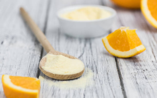 istock Wooden table with orange fruit powder (selective focus) 875584040