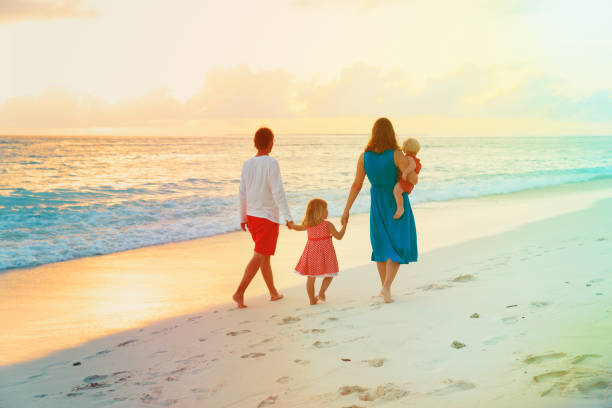 istock happy family with kids walk on sunset beach 875584304