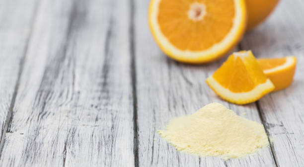istock Wooden table with orange fruit powder (selective focus) 875585780
