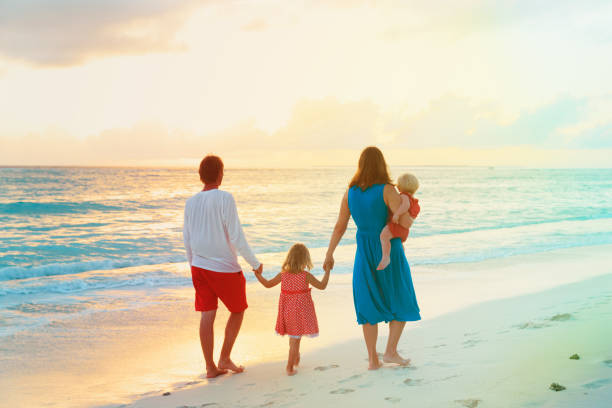 istock happy family with kids walk on sunset beach 875586418