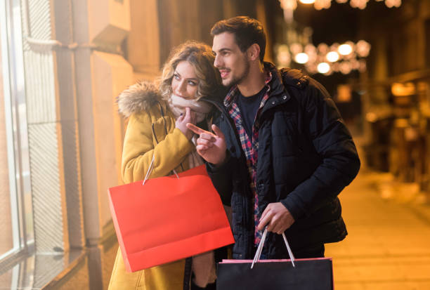 istock Couple at night looking at the shopping window 875586686