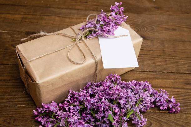 istock Bouquet of lilacs on a wooden table with a gift box 875590244