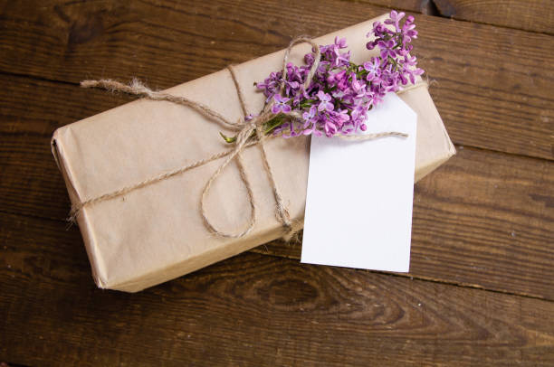 istock Bouquet of lilacs on a wooden table with a gift box 875590342