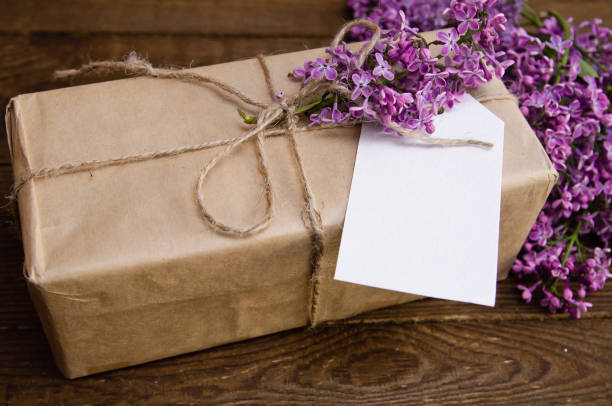 istock Bouquet of lilacs on a wooden table with a gift box 875590368