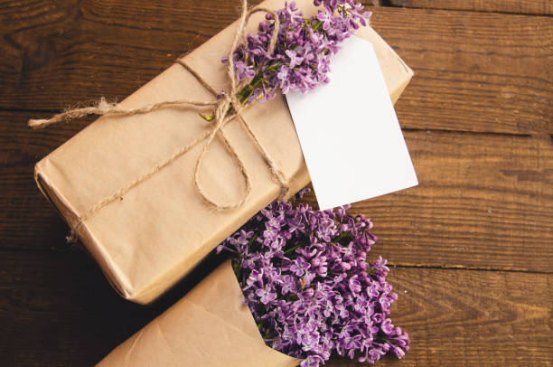 istock Bouquet of lilacs on a wooden table with a gift box 875590924