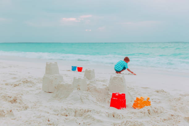 istock little boy building sand castle on beach 875591204