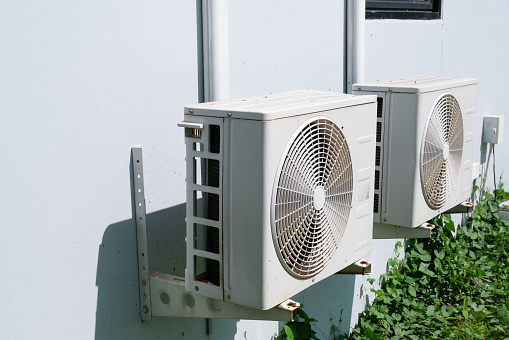 Air conditioner condenser unit at a concrete wall