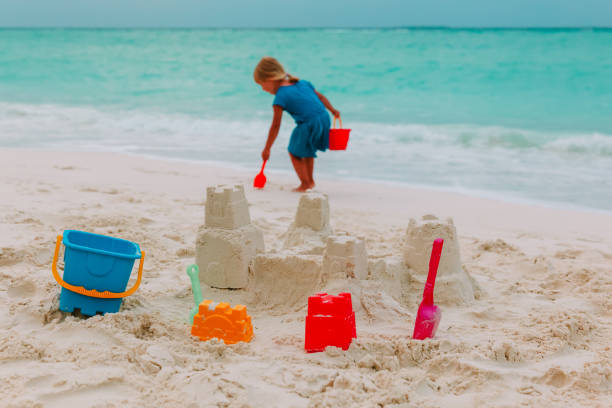 istock little girl building sand castle on beach 875592444