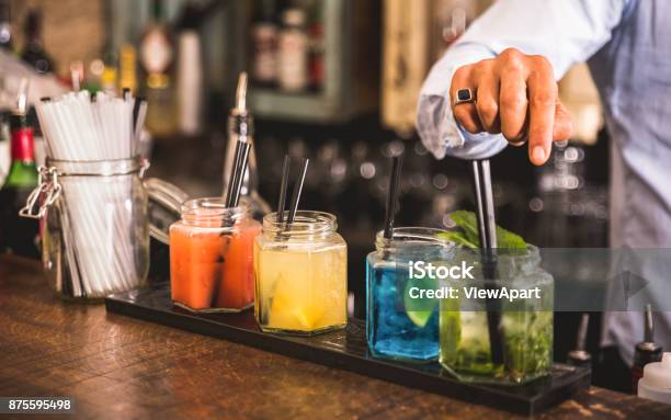 Bartender Hand At Multicolored Fashion Drink With Straw On Vintage Glass Cups In Fashion Cocktail Bar Food And Beverage Concept With Professional Barman Working At Mixology Restaurant Vivid Colors Stock Photo - Download Image Now