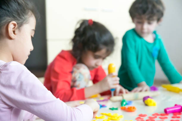 istock Cute children playing with dough in living room 875596272