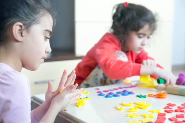 istock Cute children playing with dough in living room 875596276
