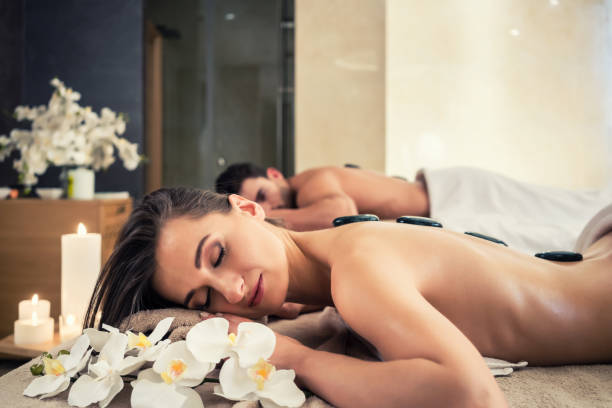istock Young couple relaxing under the stimulating effects of a hot stone massage 875596704
