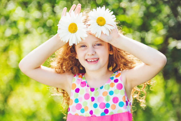 istock Child with daisy in a summer park. 875603134