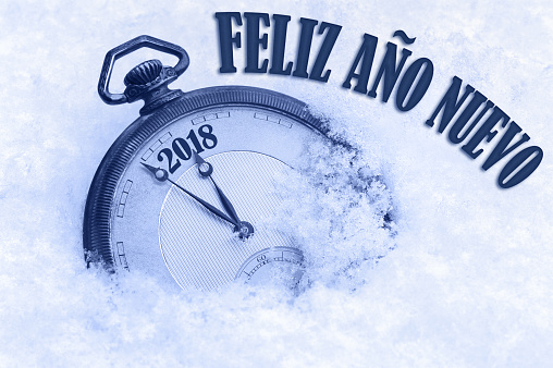 2018 saludo, feliz año nuevo en idioma español, Feliz ano nuevo texto, reloj de bolsillo en nieve photo