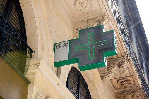 French Pharmacy Neon Green Sign symbols on the wall of the building