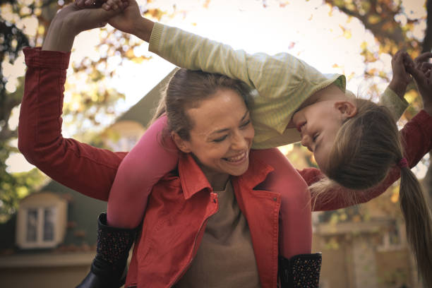 istock Mother have play with daughter, carrying her on piggyback. 875618028