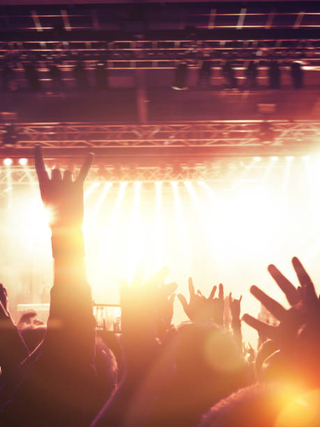 istock Golden light on raised concert hands 875629740