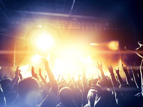 istock Colorful concert with people raising hands 875629746