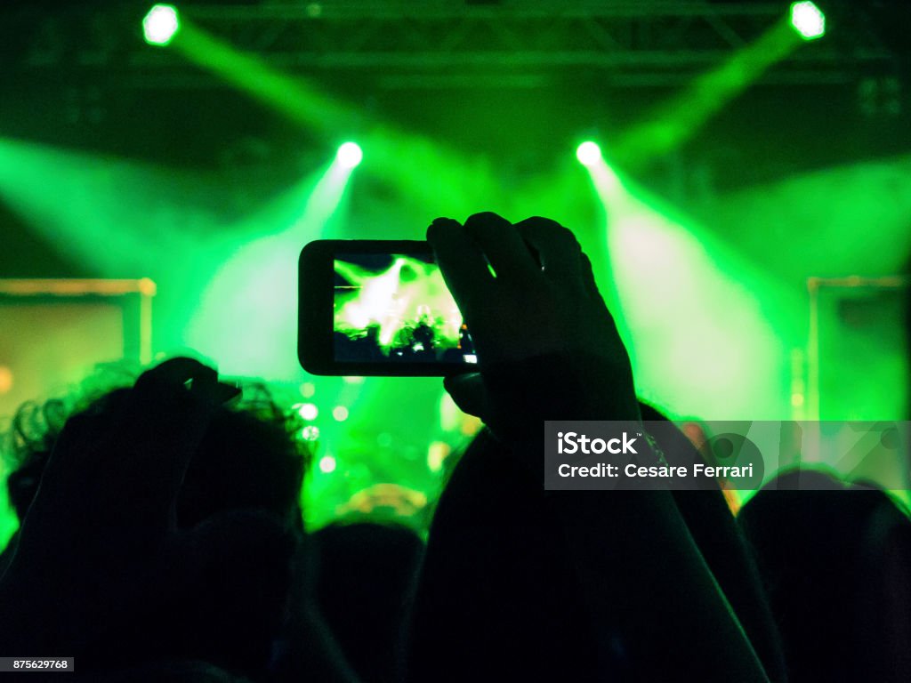 Smart phone filming a gig Detail of a hand holding a smart phone and filming a concert. Arts Culture and Entertainment Stock Photo