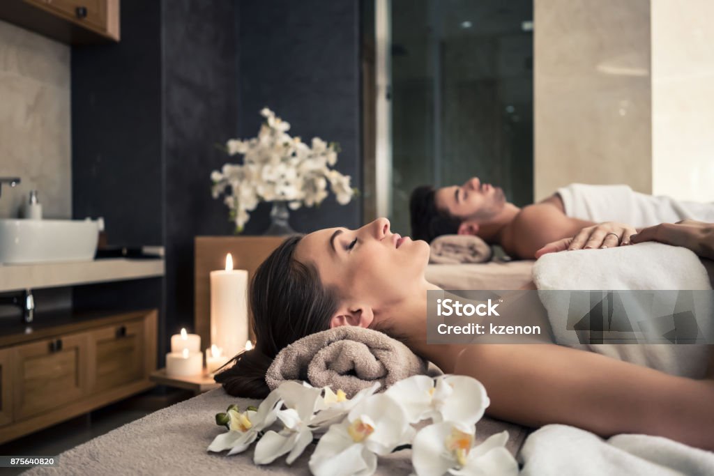 Man and woman lying down on massage beds at Asian wellness center Young man and woman lying down on massage beds at Asian luxury spa and wellness center Spa Stock Photo