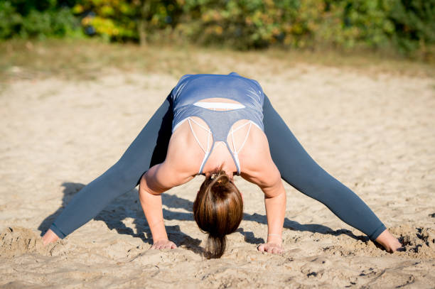 istock Woman practicing yoga in the sand 875647208