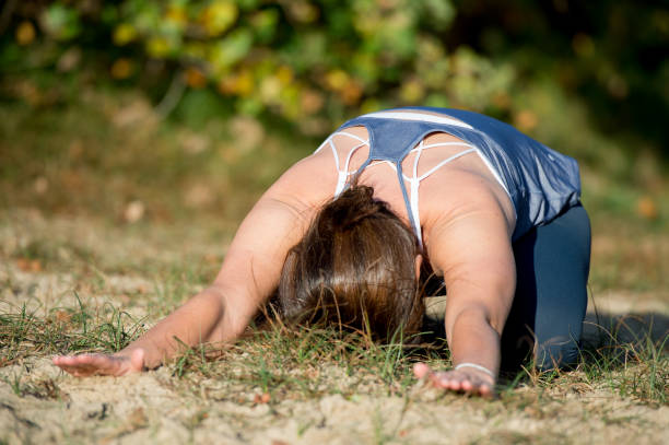 istock Woman practicing yoga in the sand 875647264