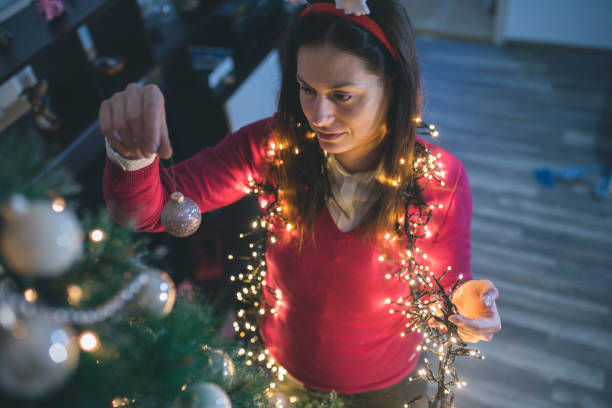 自宅のクリスマス ツリーを飾る幸せな若い女 - christmas ball christmas ornament human hand ストックフォトと画像