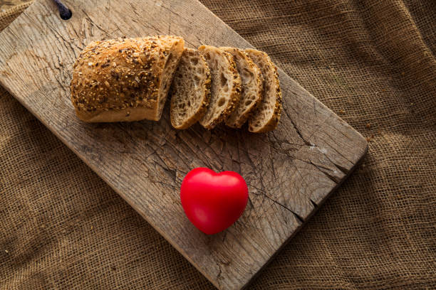 istock Sliced bread on a cutting board with red heart shape figure 875650794