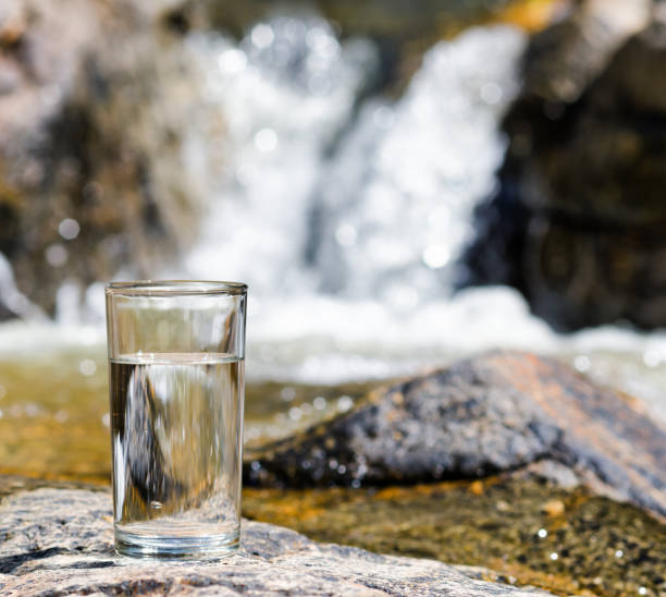 istock Glass of water by waterfall 875651126