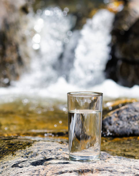 istock Glass of water by waterfall 875651176
